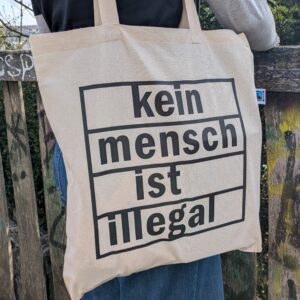 Naturfarbene Tasche mit chwarzem Aufdruck 'Kein Mensch ist illegal'